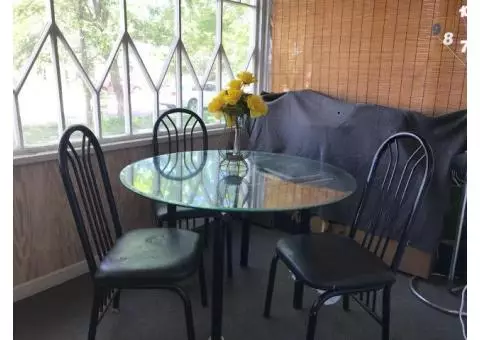 Round glass dining room table and three