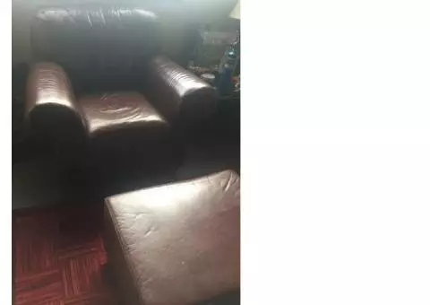 Overstuffed leather chair with footrest and matching sofa