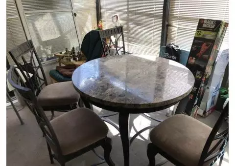 Dining room table with four chairs. Rod iron with Marble top.